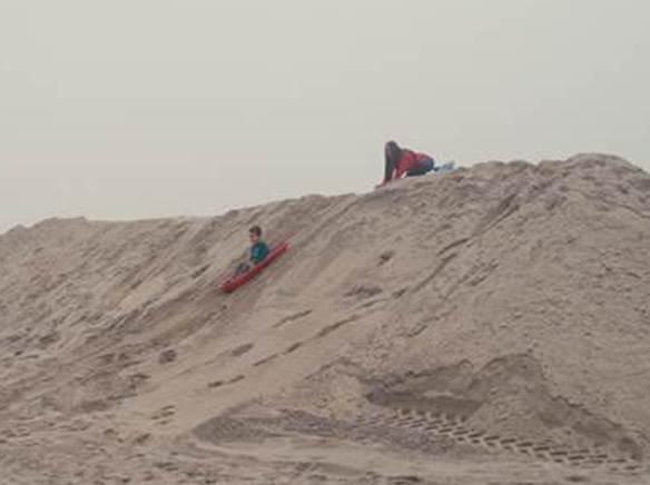 Winter sand berm transforms into sled hill in Huntington Beach